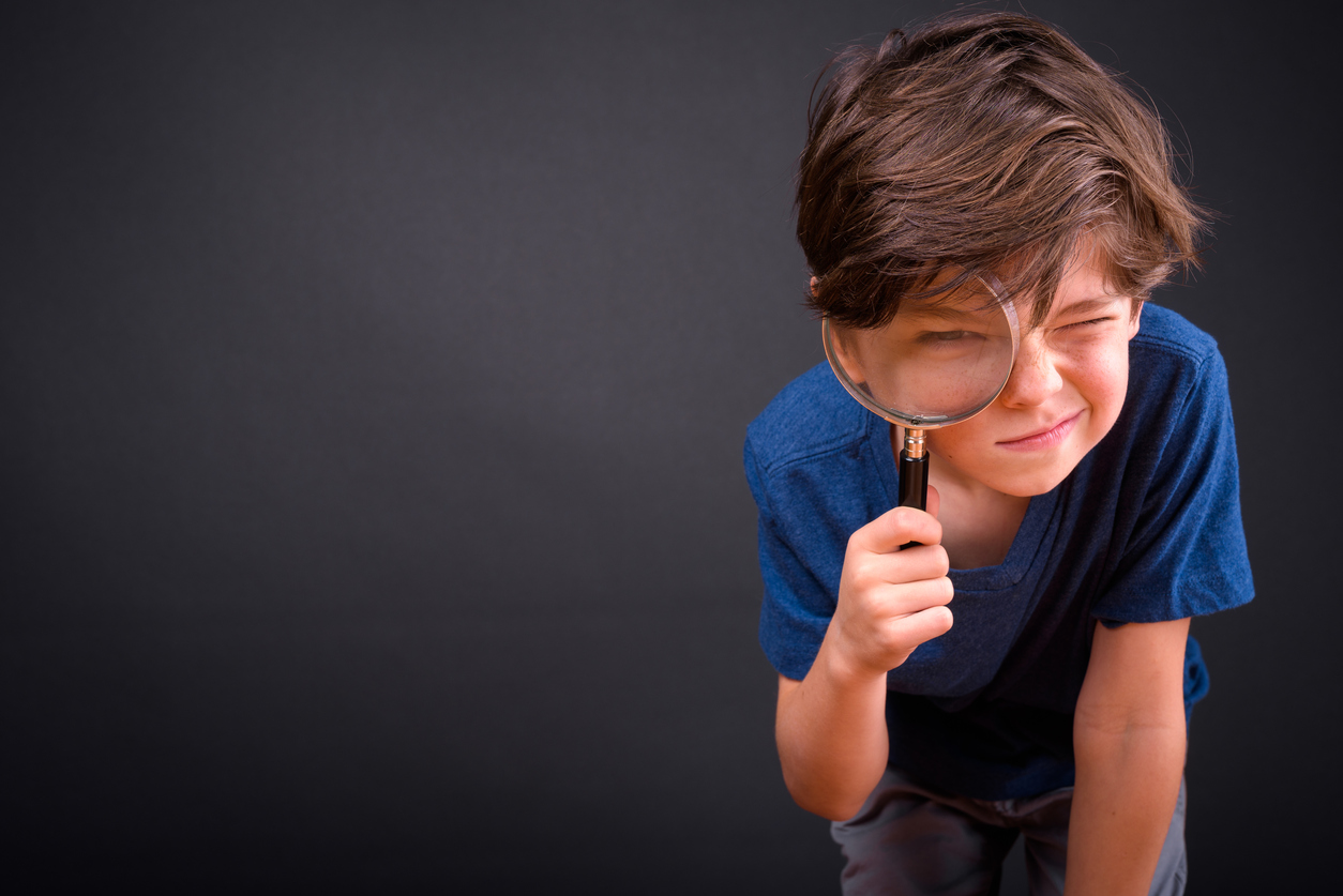 Boy searching using a magnifying glass