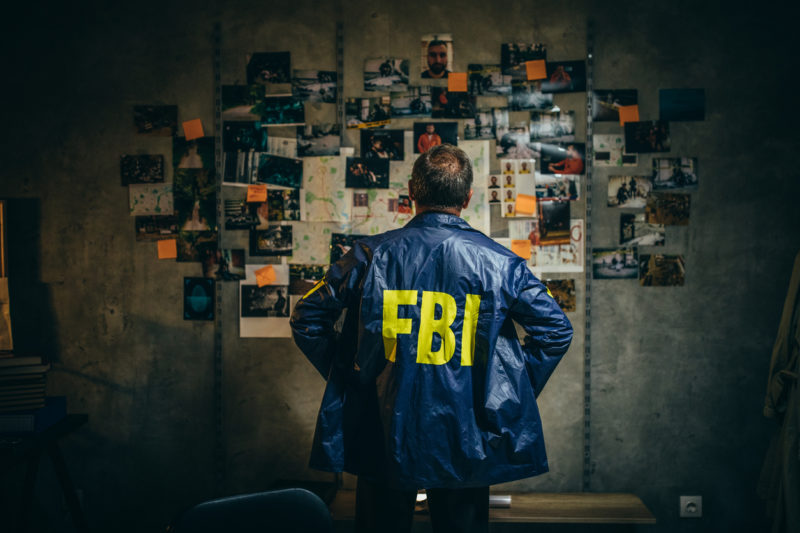 An FBI agent looks at case photos