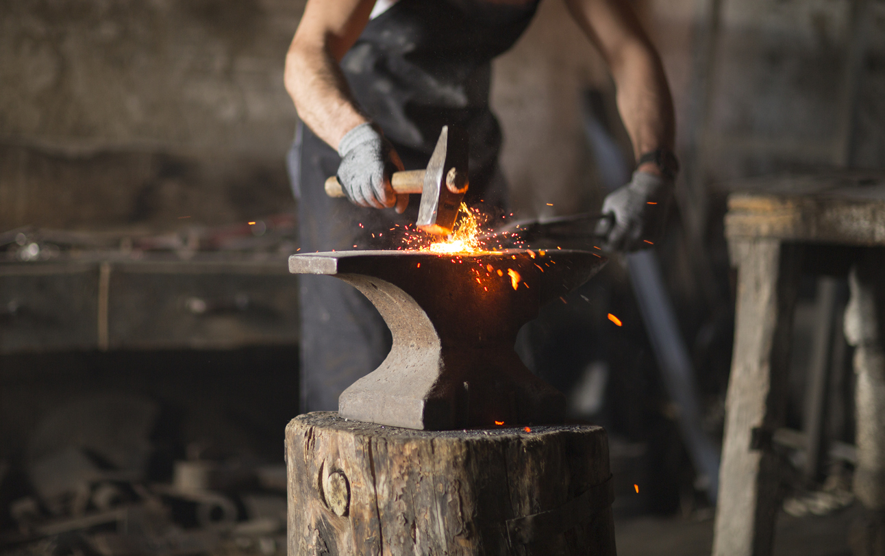Blacksmith hammering iron