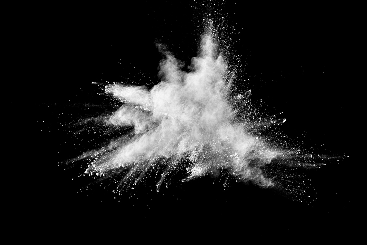 White powder explosion against black background