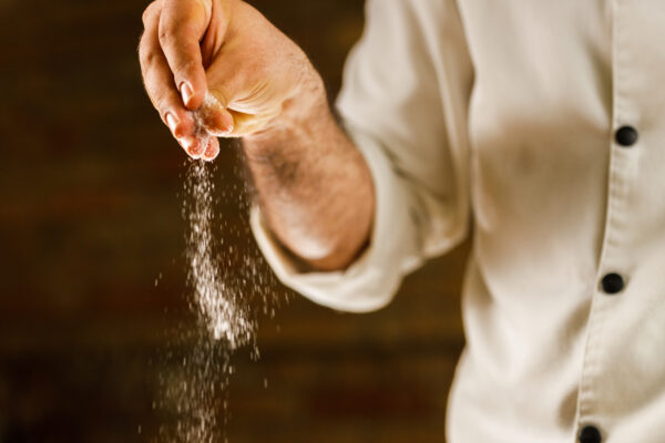 Chef adding salt