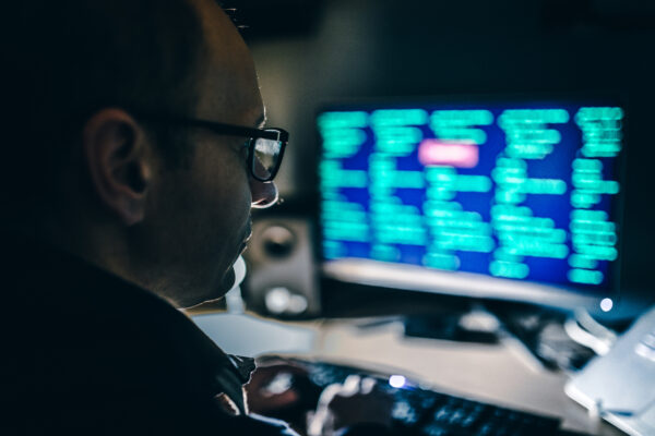 Man looking at computer screen code