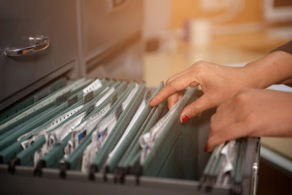 Woman handling file folders in a drawer