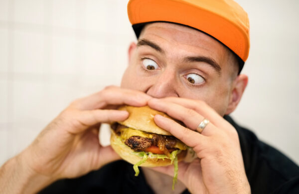 Man trying to eat a large hamburger