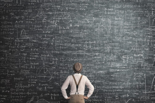 Man standing at a chalkboard thinking hard