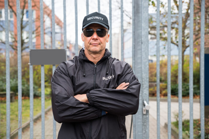 Security guard in front of a property's gate