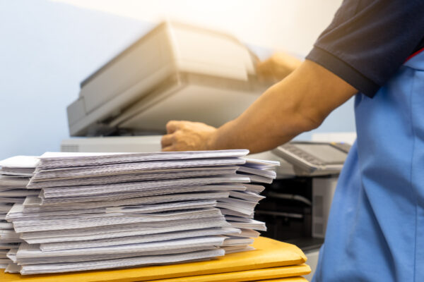 Person using a scanner to scan stacks of records