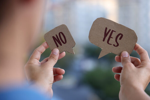 Person holding Yes and No signs in hand