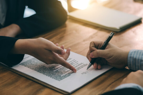 Two people signing an agreement