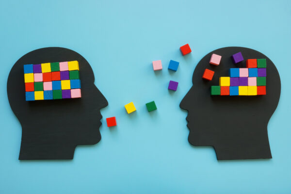 Concept of two heads talking to each other, colored blocks representing ideas and words