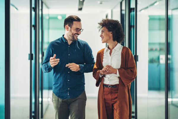 Two workers walking and talking in a hallway