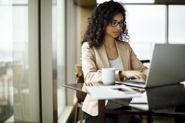 Young businesswoman working on laptop at a cafe