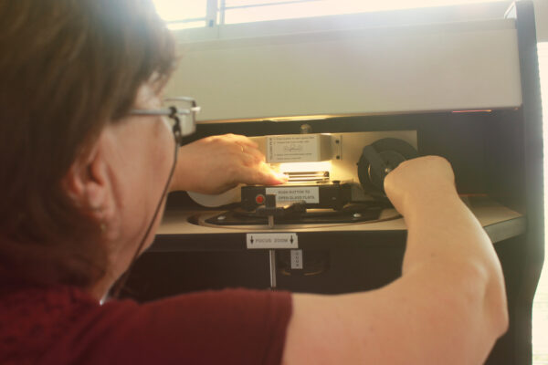 Librarian using a microfilm reader