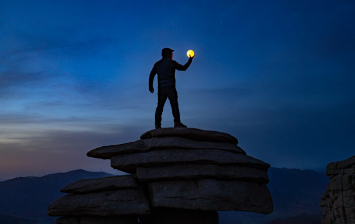 Man holding the moon like a crystal ball